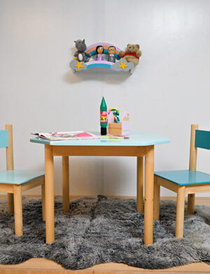 a table and chairs with toys on the wall