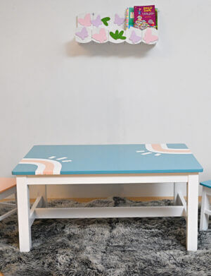 a blue and white coffee table with white and pink painted sun designs