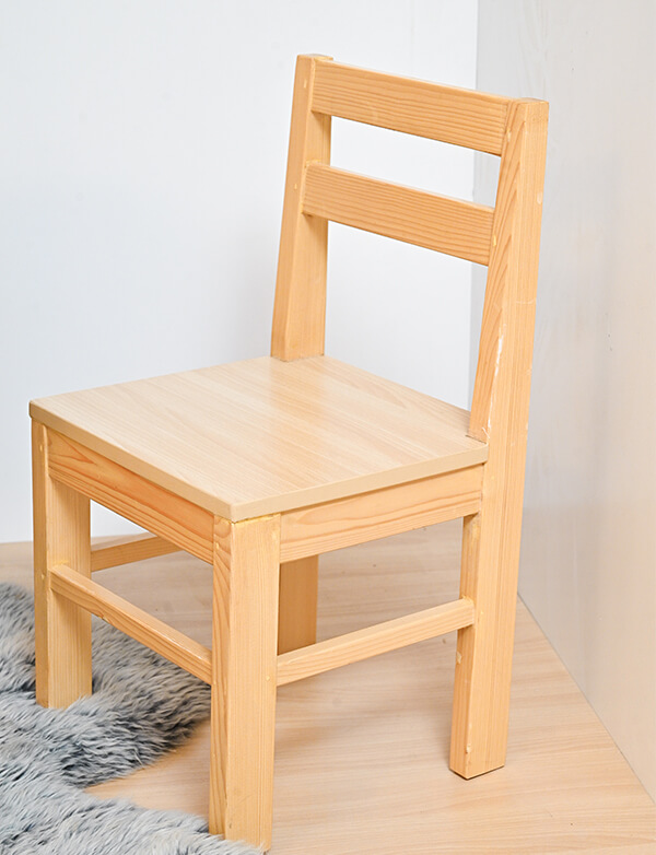a wooden chair on a wooden floor with gry rug