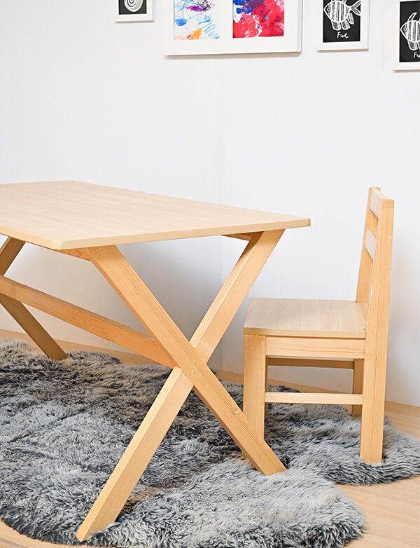 a wooden table and chair on a gry rug